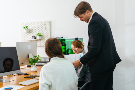 Financial analyst working on multiple monitors displaying stock market charts, financial data, and trading analytics. Intense trading environment for investment, finance, and technologyの写真素材