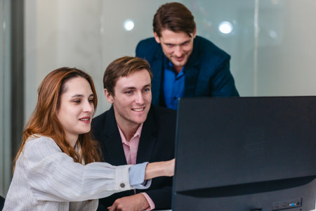 Financial analyst working on multiple monitors displaying stock market charts, financial data, and...