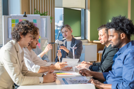 A diverse startup team develop, collaborates on a powerful, lightweight, portable wind turbine prototype, aligning with potential user demand and renewable energy needs to secure investor funding.の写真素材