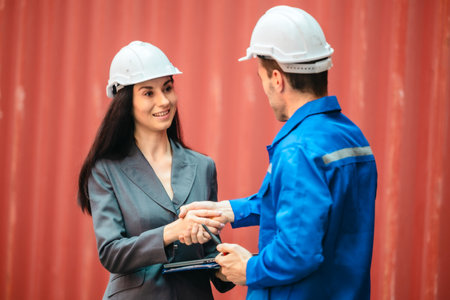 Industrial container workers discussing eco-friendly logistics strategies. Reducing fuel...