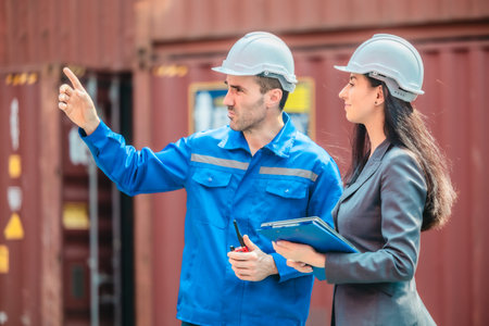 Industrial container workers discussing eco-friendly logistics strategies. Reducing fuel...