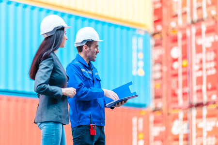 Industrial container workers discussing eco-friendly logistics strategies. Reducing fuel...