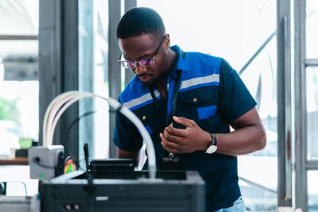 Engineer examines freshly printed 3D component in a workshop , showcasing advanced manufacturing and prototyping technology. Reflecting innovation, precision engineering, industrial design processesの写真素材