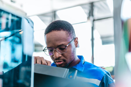 Engineer examines freshly printed 3D component in a workshop , showcasing advanced manufacturing and prototyping technology. Reflecting innovation, precision engineering, industrial design processesの写真素材