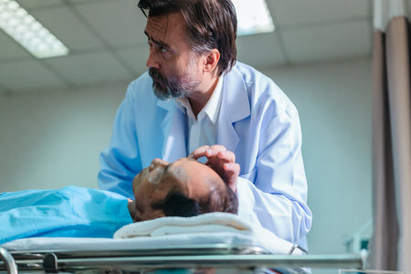 Senior physician carefully examines patient's vital signs while the patient lies in a hospital bed,...