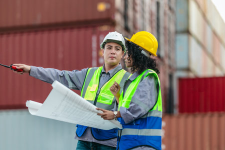 Industrial container workers discuss sustainable logistics operations. Analyzing blueprint,...