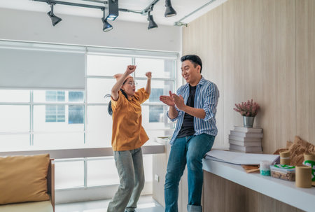 Team members enthusiastically celebrate a successful project in a modern office setting. The moment...