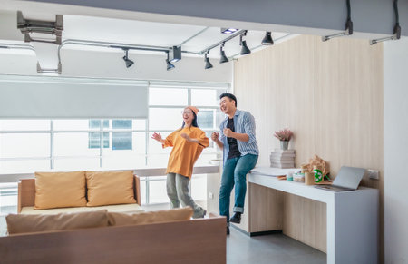 Team members enthusiastically celebrate a successful project in a modern office setting. The moment captures teamwork, motivation, and the joy of achieving goals in a startup environment.の写真素材