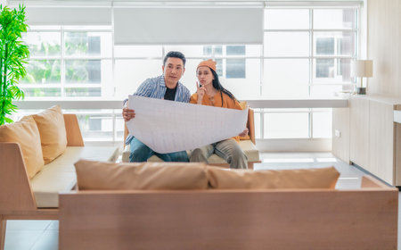 Two professionals review a large planning sheet together in a bright, modern workspace. The scene reflects teamwork, strategic thinking, and collaborative project development.の写真素材