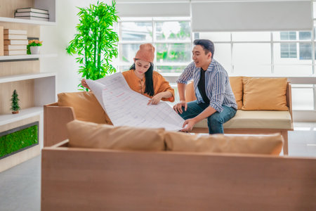 Two professionals review a large planning sheet together in a bright, modern workspace. The scene...