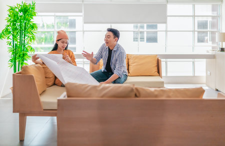 Two professionals review a large planning sheet together in a bright, modern workspace. The scene reflects teamwork, strategic thinking, and collaborative project development.の写真素材