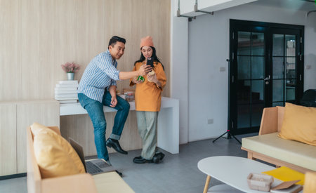 Two business partners evaluate various sustainable packaging materials in modern workspace. Highlighting creative collaboration, product design, and environmentally conscious business practices.の写真素材