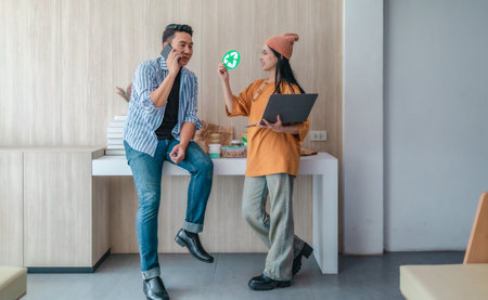 Two business partners evaluate various sustainable packaging materials in modern workspace. Highlighting creative collaboration, product design, and environmentally conscious business practices.の写真素材