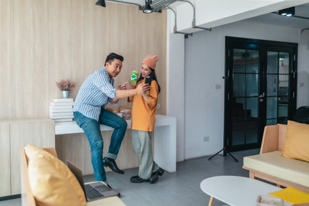 Two business partners evaluate various sustainable packaging materials in modern workspace. Highlighting creative collaboration, product design, and environmentally conscious business practices.の写真素材