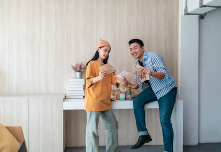 Two business partners evaluate various sustainable packaging materials in modern workspace. Highlighting creative collaboration, product design, and environmentally conscious business practices.の写真素材