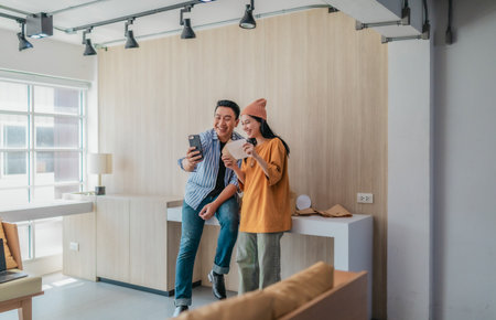 Two business partners evaluate various packaging materials in modern workspace. Highlighting...