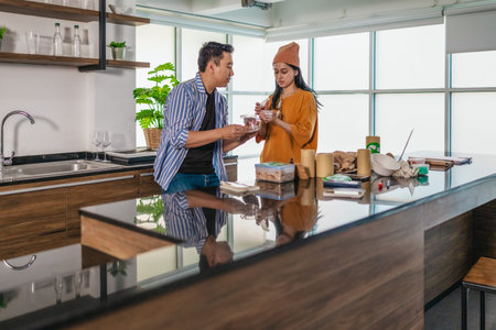 Two entrepreneurs review sustainable packaging samples in a modern workspace. Surrounded by eco-friendly materials and product prototypes, they discuss ideas for product developmentの写真素材