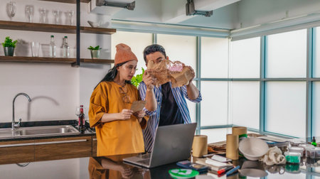 Two entrepreneurs review sustainable packaging samples in a modern workspace. Surrounded by eco-friendly materials and product prototypes, they discuss ideas for product development and brandingの写真素材