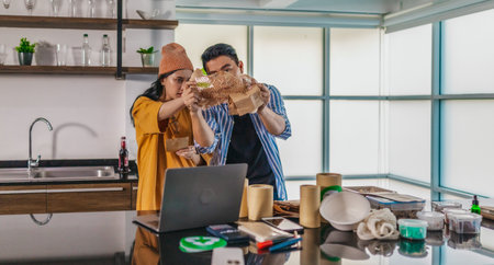 Two entrepreneurs review sustainable packaging samples in a modern workspace. Surrounded by eco-friendly materials and product prototypes, they discuss ideas for product development and brandingの写真素材