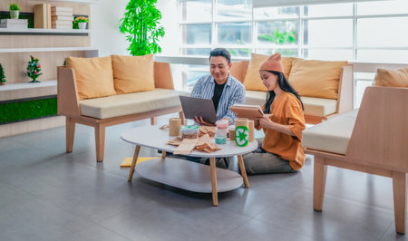 Two entrepreneurs review sustainable packaging samples in a modern workspace. Surrounded by eco-friendly materials and product prototypes, they discuss ideas for product development and brandingの写真素材