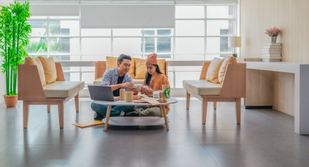 Two entrepreneurs review sustainable packaging samples in a modern workspace. Surrounded by eco-friendly materials and product prototypes, they discuss ideas for product development and brandingの写真素材