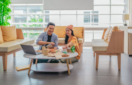 Two entrepreneurs review packaging samples in a modern workspace. Surrounded by eco-friendly materials and product prototypes, they discuss ideas for product development.の写真素材