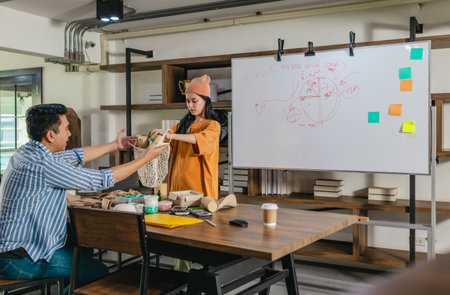 Creative startup team brainstorming innovative and eco-friendly packaging solutions. Reflecting sustainable thinking, teamwork, and product development in a dynamic business environmentの写真素材