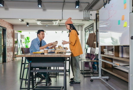 Creative startup team brainstorming innovative and eco-friendly packaging solutions. Reflecting sustainable thinking, teamwork, and product development in a dynamic business environmentの写真素材