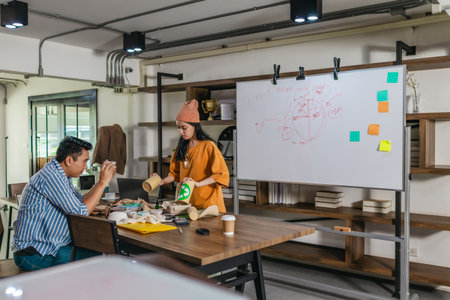 Creative startup team brainstorming innovative and eco-friendly packaging solutions. Reflecting sustainable thinking, teamwork, and product development in a dynamic business environmentの写真素材