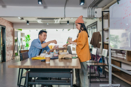 Creative startup team brainstorming innovative and eco-friendly packaging solutions. Reflecting sustainable thinking, teamwork, and product development in a dynamic business environmentの写真素材