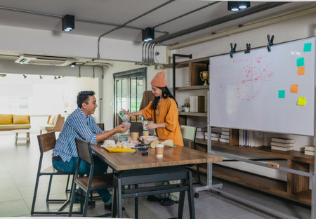 Creative startup team brainstorming innovative and eco-friendly packaging solutions. Reflecting sustainable thinking, teamwork, and product development in a dynamic business environmentの写真素材