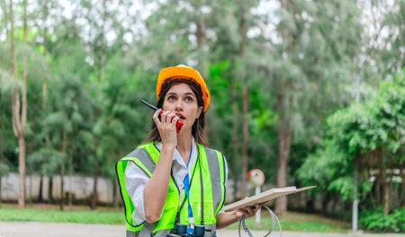 Female environmental surveyor observes forest conditions using binoculars, takes notes, communicates...