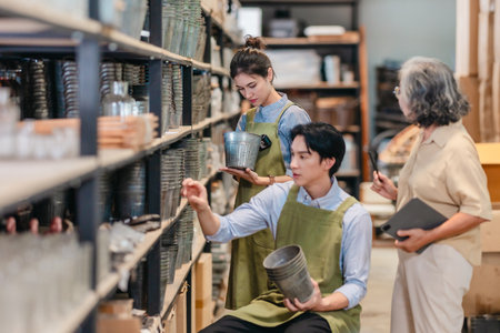 Mother and owner educates her children in family business warehouse. Material selection, product quality, sustainable recycling practices to improve production efficiency and eco friendly operationsの写真素材