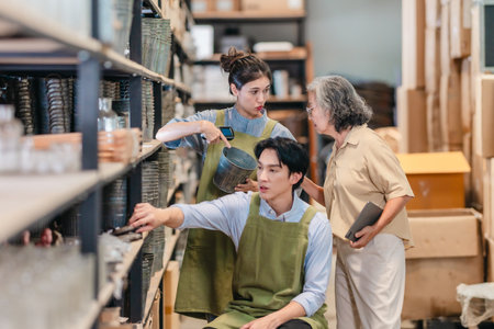 Mother and owner educates her children in family business warehouse. Material selection, product quality, sustainable recycling practices to improve production efficiency and eco friendly operationsの写真素材