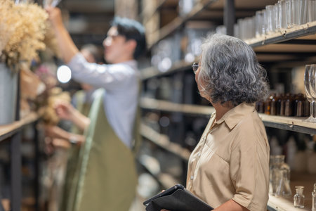 Mother and owner educates her children in family business warehouse. Material selection, product quality, sustainable recycling practices to improve production efficiency and eco friendly operationsの写真素材