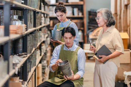 Mother and owner educates her children in family business warehouse. Material selection, product quality, sustainable recycling practices to improve production efficiency and eco friendly operationsの写真素材