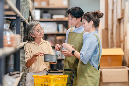 Mother and owner educates her children in family business warehouse. Material selection, product quality, sustainable recycling practices to improve production efficiency and eco friendly operationsの写真素材