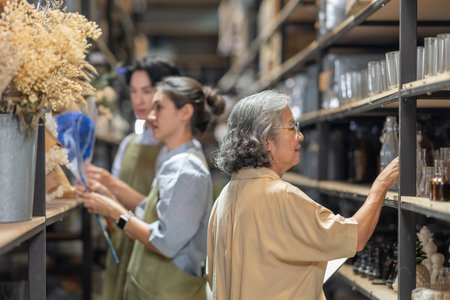 Mother and owner educates her children in family business warehouse. Material selection, product quality, sustainable recycling practices to improve production efficiency and eco friendly operationsの写真素材