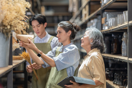 Mother and owner educates her children in family business warehouse. Material selection, product quality, sustainable recycling practices to improve production efficiency and eco friendly operationsの写真素材
