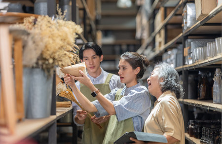 Mother and owner educates her children in family business warehouse. Material selection, product quality, sustainable recycling practices to improve production efficiency and eco friendly operationsの写真素材