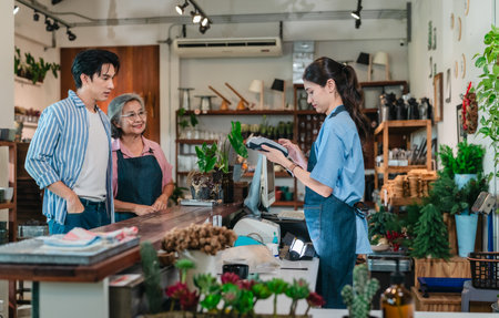 At a family run ceramic store, a mother and daughter provide friendly service to a male customer at...