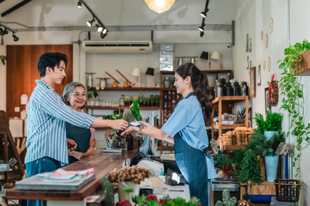 At a family run ceramic store, a mother and daughter provide friendly service to a male customer at...
