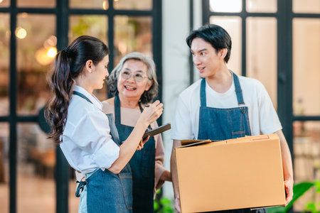 Mother, daughter, and son pose outside their family run ceramic shop and warehouse, presenting a friendly, professional team ready for retail and wholesale customers.の写真素材