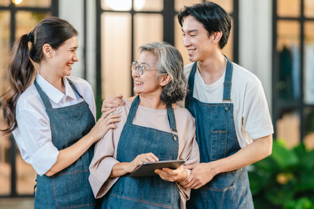 Mother, daughter, and son pose outside their family run ceramic shop and warehouse, presenting a friendly, professional team ready for retail and wholesale customers.の写真素材