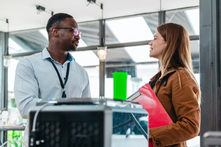 Two product designers examine and discuss 3D printed prototypes in design studio. Highlighting teamwork, creativity, and hands-on testing in product development using additive manufacturing technologyの写真素材