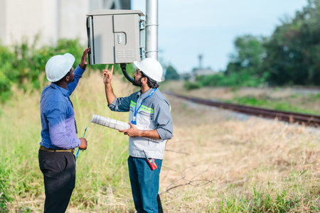 Engineer presents railway development proposal to investor during site visit, discussing green...