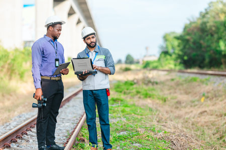 Engineer presents railway development proposal to investor during site visit, discussing green...