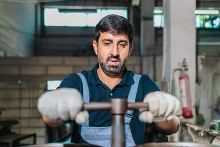 Technician performs hands-on maintenance and precise machine adjustment on heavy industrial...