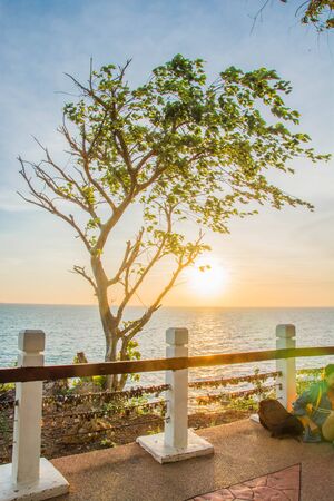 A scenery of a wooden rail with a love keys on a mountain with sea and sunset behind the rail in Chanthaburi Thailand.の写真素材