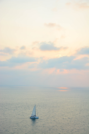 Sail boat sailing along the sea in Phuket Thailand at PromThep cape at sunset.の写真素材